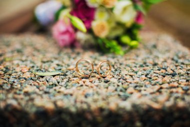 bir buket çiçek önünde bir taş alyans yalan