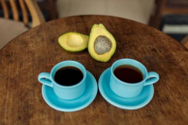 Голубая чашка кофе и авокадо — стоковое фото