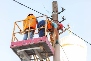 Sütunlardaki elektrikçiler elektrik hattına monte ediyorlar. Profesyonel elektrikçiler kulede çalışıyor. Dnipro / Ukrayna - 08.10.2019