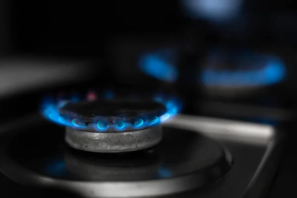 Gas stove, gas is burning. Gas burner on a dark background.