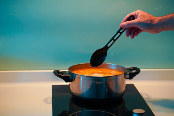 Cooking soup in a pan on an induction stove.