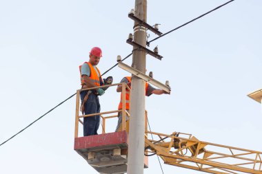 Sütunlardaki elektrikçiler elektrik hattına monte ediyorlar. Profesyonel elektrikçiler kulede çalışıyor. Dnipro / Ukrayna - 08.10.2019