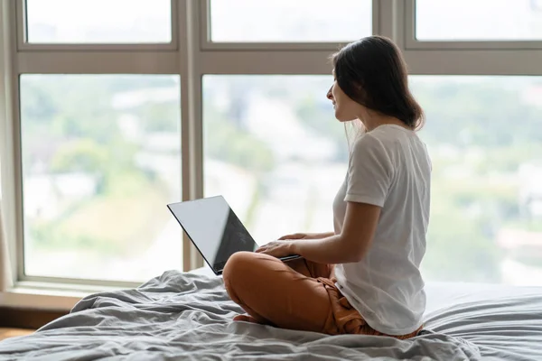 Красива Молода Брюнетка Працює Ноутбуці Сидячи Ліжку Біля Панорамного Вікна — стокове фото