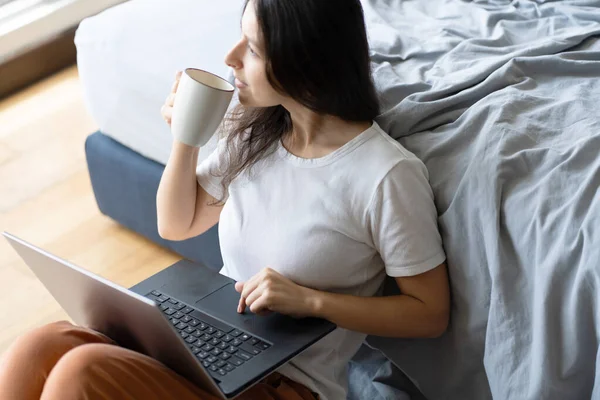 Hermosa Joven Morena Trabajando Portátil Tomando Café Sentada Suelo Cerca — Foto de Stock