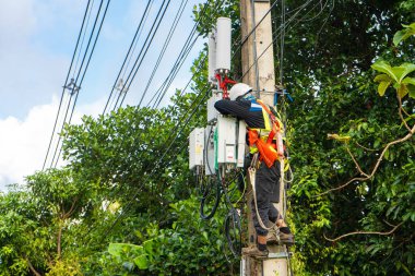 Profesyonel bir elektrikçi direkte tesisat işi yapar. Tehlikeli koşullarda çalışan profesyonel ekipmanlı bir elektrikçi. samui / tailand - 02.24.2020