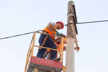 Sütunlardaki elektrikçiler elektrik hattına monte ediyorlar. Profesyonel elektrikçiler kulede çalışıyor. Dnipro / Ukrayna - 08.10.2019