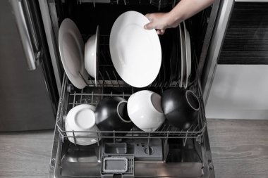 Bulaşık makinesine kirli bulaşıkları yüklüyorum..