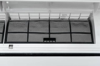 Adam evdeki klimanın filtresini tozdan temizliyor. Çok kirli bir klima filtresi. İklim ekipmanı bakımı