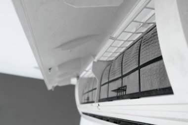 Adam evdeki klimanın filtresini tozdan temizliyor. Çok kirli bir klima filtresi. İklim ekipmanı bakımı