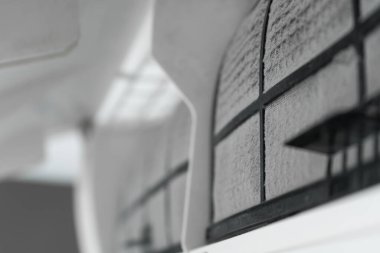 Adam evdeki klimanın filtresini tozdan temizliyor. Çok kirli bir klima filtresi. İklim ekipmanı bakımı