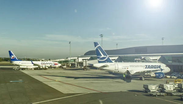 На взлетно-посадочной полосе аэродрома стоят самолеты различных авиакомпаний — стоковое фото