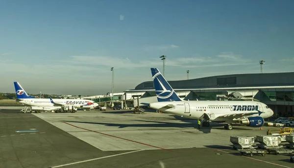 На взлетно-посадочной полосе аэродрома стоят самолеты различных авиакомпаний — стоковое фото