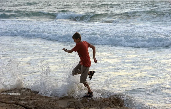 Boy runs along the shore — Stock Photo, Image