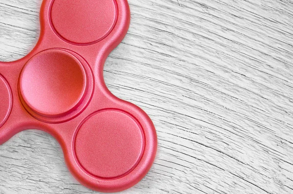 Red fidget spinner sobre fondo de madera blanca. Juguete para aliviar el estrés . — Foto de Stock