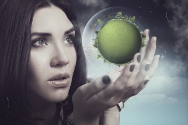 Woman holding green planet in hands clipart
