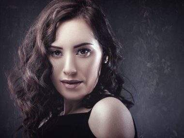 Esmer kadın kameraya bakıyor.