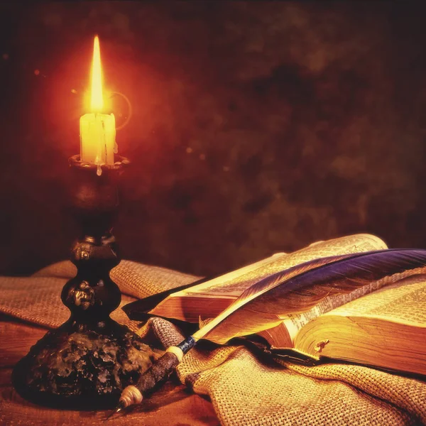 Libro aperto, piuma e candela — Foto Stock
