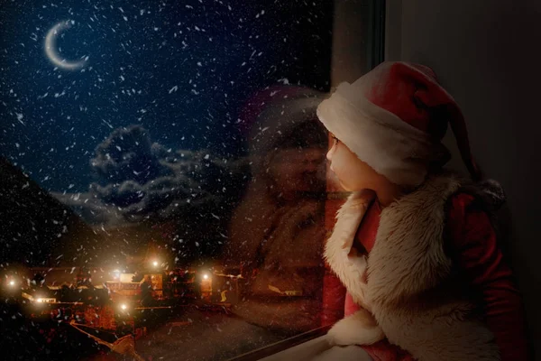 Barnet ser ut genom fönstret på juldagen — Stockfoto