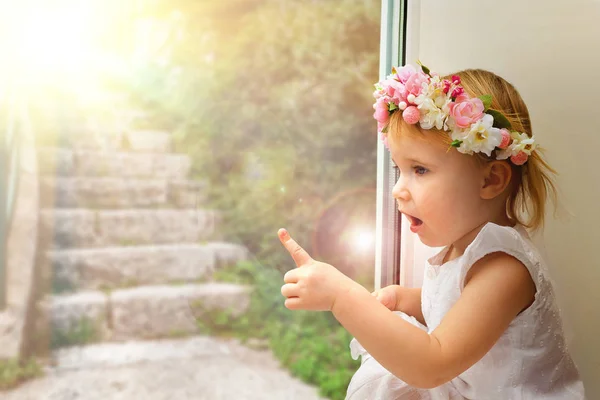 Ребенок смотрит в весеннее окно — стоковое фото