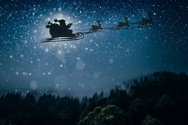 Silhouette eines fliegenden Weihnachtsmannes vor dem Hintergrund des Nachthimmels. — Stockfoto