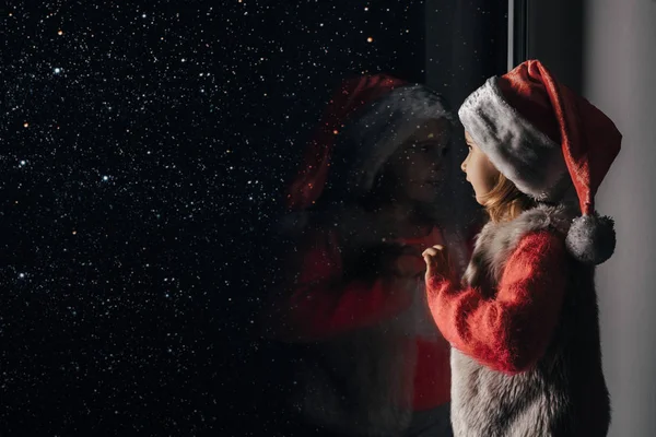 Enfant regarde par la fenêtre sur Noël de Jésus-Christ . — Photo