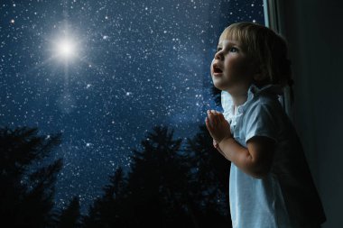 çocuk pencereden Noel gününde görünüyor.