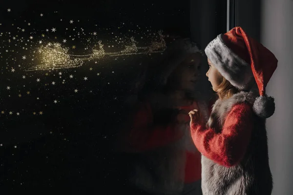 Enfant regarde par la fenêtre sur Noël de Jésus-Christ . — Photo