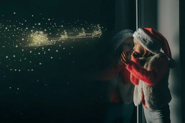 Il bambino guarda fuori dalla finestra il giorno di Natale — Foto Stock