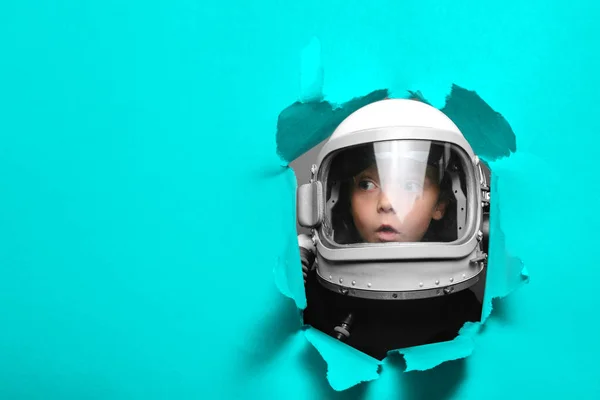 Klein kind in het dragen van een vliegtuig helm kijken door een gat — Stockfoto