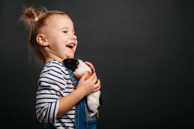 Mutlu şirin çocuk siyah sırtında çöreklerle eğleniyor.