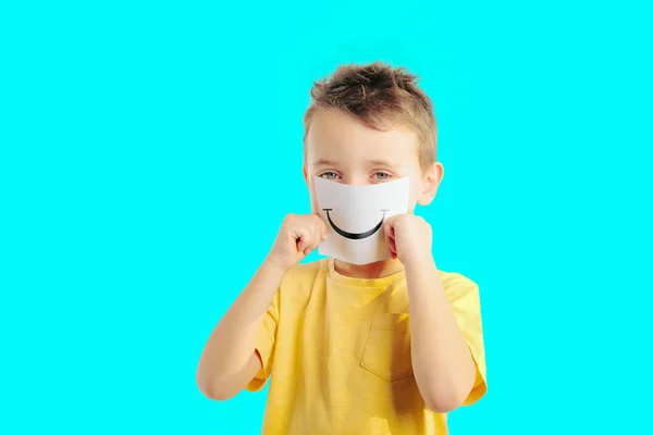 Little child holding a card with smiling face. Boy chooses an em — Stock Photo, Image