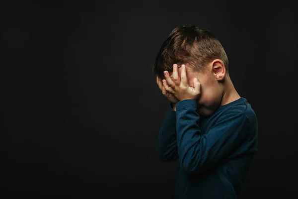 Kind wiens depressie is op een zwarte achtergrond — Stockfoto