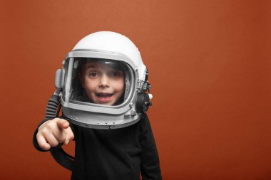 Küçük çocuk uzayda Lush Lavabackground 'da astronot kaskı takarak uçmak istiyor.