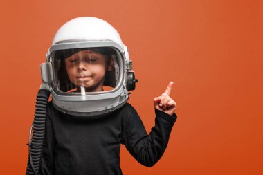  Küçük çocuk uzayda Lush Lav arka planında astronot kaskı takarak uçmak istiyor.