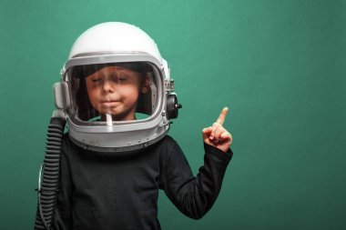  Küçük çocuk Aqua Menthe arka planında astronot kaskı takarak uzayda uçmak istiyor.
