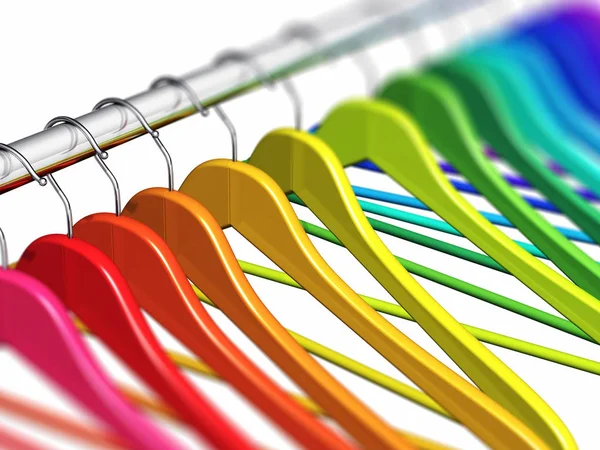 Rainbow coat hangers on clothes rail — Stock Photo, Image