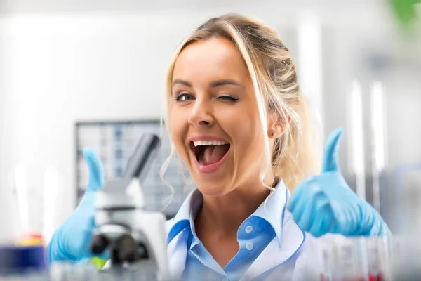 Joven atractiva mujer sonriente científica es feliz con su trabajo —  Fotos de Stock