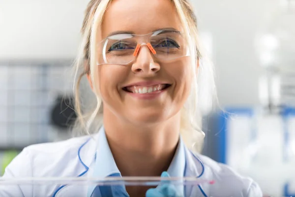 Счастливая молодая привлекательная улыбающаяся женщина-ученый в лаборатории — стоковое фото