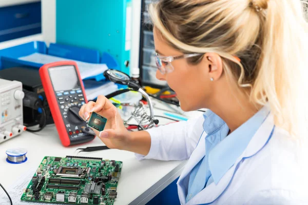 Kvinnliga elektroniska ingenjör kontrollera Cpu mikrochip i laboratorium — Stockfoto