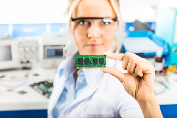 Fiatal női elektronikai mérnök a kezében tartja a memória modul — Stock Fotó