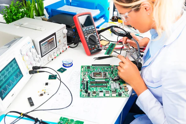Ingeniera electrónica femenina comprobando placa de circuito en laboratorio —  Fotos de Stock
