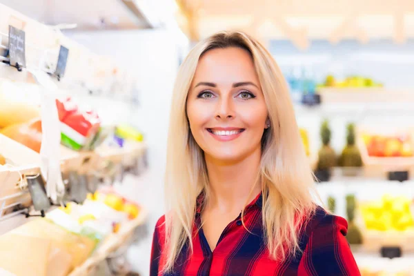 Счастливая молодая женщина в продовольственном магазине — стоковое фото