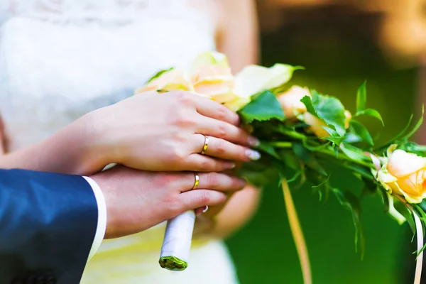 Руки жениха и невесты с золотыми обручальными кольцами — стоковое фото