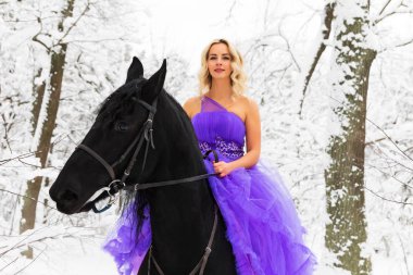 Kışın bir binicilik uzun elbiseli genç kadın