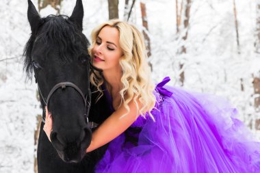 Kışın bir binicilik uzun elbiseli genç kadın