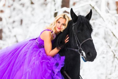 Kışın bir binicilik uzun elbiseli genç kadın