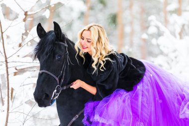 Kışın bir binicilik uzun elbiseli genç kadın