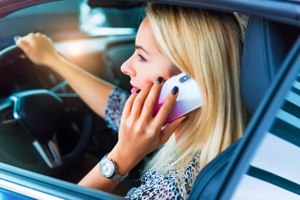 Молодая женщина водитель разговаривает по телефону в машине — стоковое фото