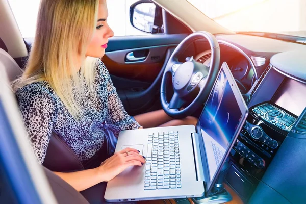 Mulher usando um laptop em seu carro — Fotografia de Stock