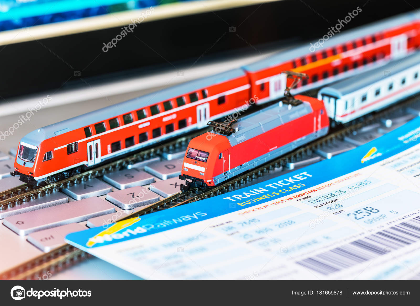 Toy train, tickets, passport and bank card on laptop or notebook Stock